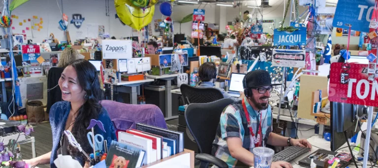 The image shows Zappos customer service where all the employees are working together to resolve issues. 