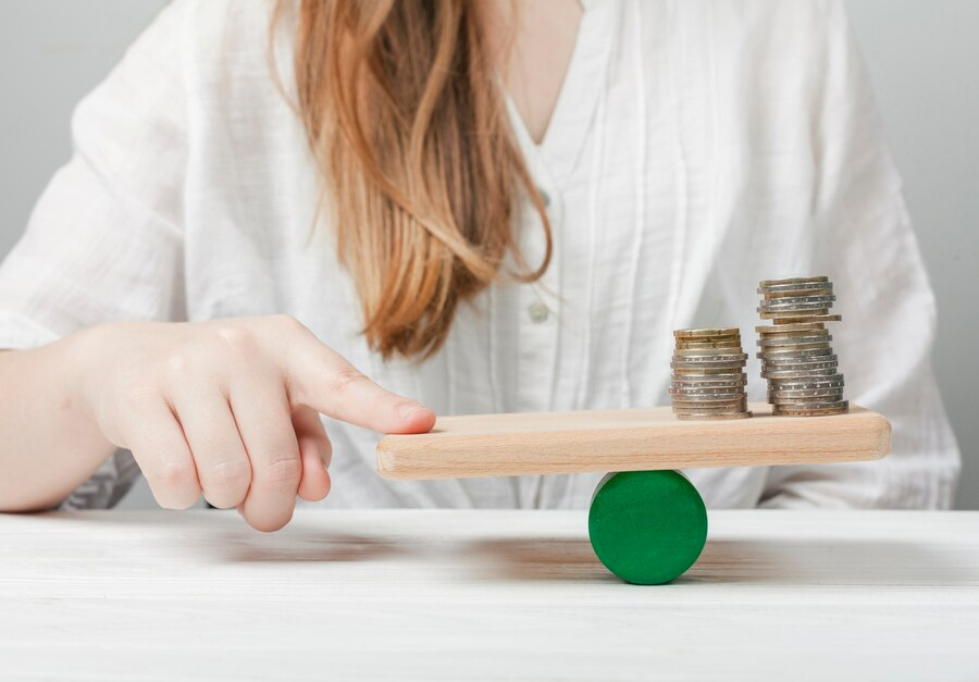The image shows a Woman holding her finger in balance with the coins 