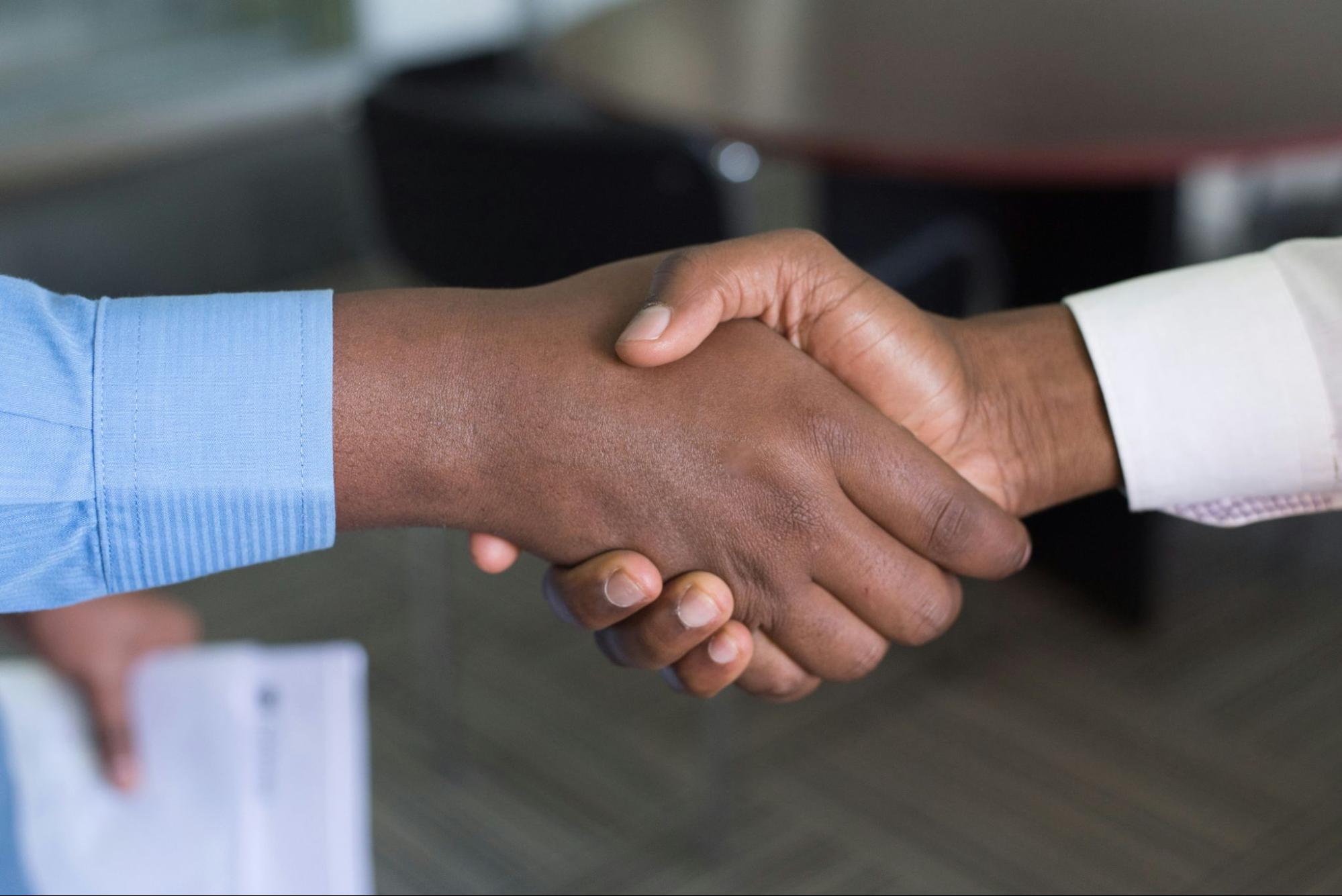 The image shows a Businessman shaking hands with their customer 