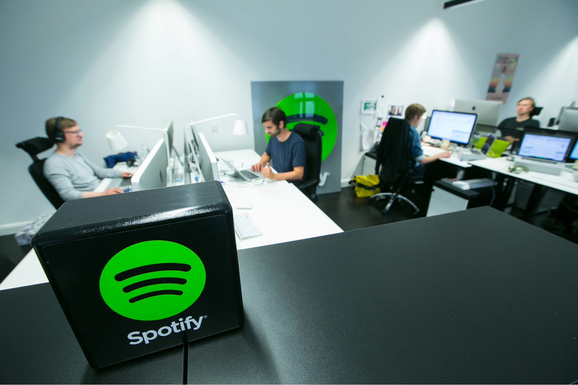 The image shows Spotify’s working space where employees are working together. 