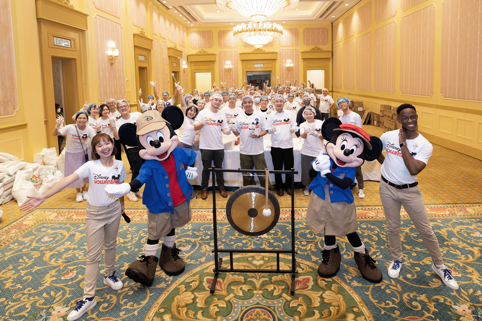 An image showing Disney’s commitment to delivering great customer service always, where Mickey Mouse and Minnie Mouse and the Disney Hotel staff are standing and welcoming guests to their resort with smiles. 